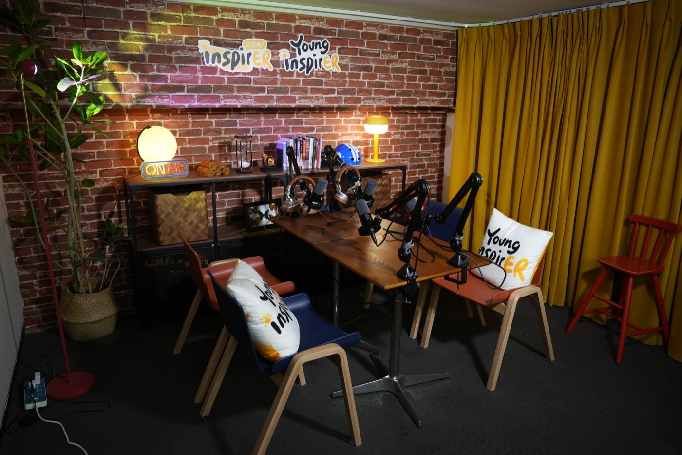 YoungInspirer podcast studio with brick wall and yellow curtains
